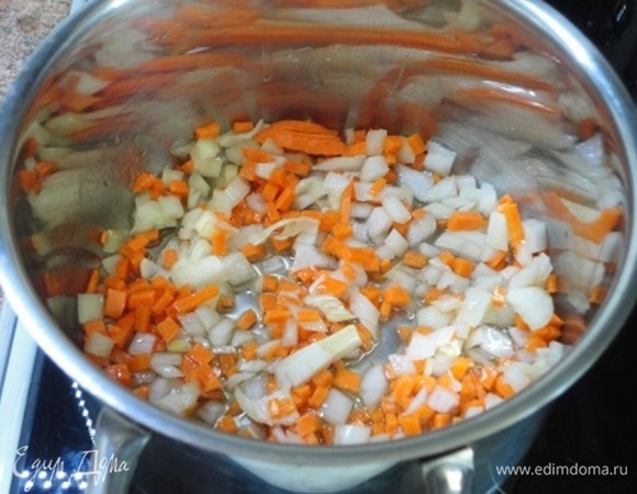 В кастрюле с толстым дном разогреваем 2 ст. л. растительного масла и обжариваем небольшие луковицу и морковь, нарезанные мелкими кубиками.