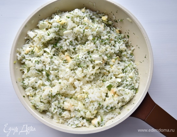 К пассерованному луку добавить отварной рис, яйца и зелень. Начинку посолить по вкусу, поперчить и перемешать.