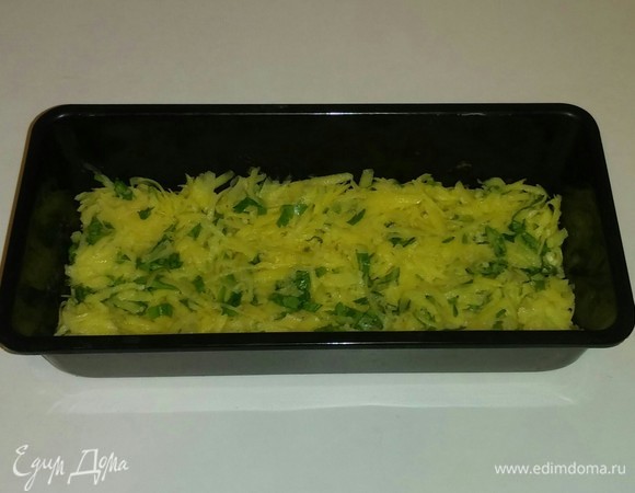 Смазываем форму для запекания оливковым маслом и выкладываем в нее натертую картошку с зеленью и чесноком, разравниваем. Затем ставим ее в разогретую до 170°C духовку минут на 20, чтобы картошка чуть-чуть пропеклась.