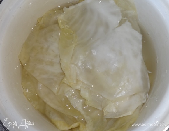 Квашеные капустные листья положить в большую кастрюлю и залить кипятком на 5–7 минут. Затем положить на дуршлаг, чтобы стекла вода.