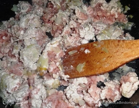 Выложить к луку фарш и продолжать обжаривать, все время помешивая и разбивая комочки фарша, в течение 10 минут.