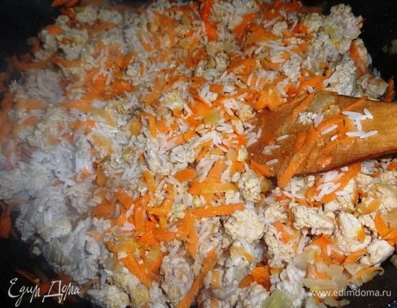 Добавить в сковороду рис, перемешать. Продолжать обжаривать вместе еще некоторое время.