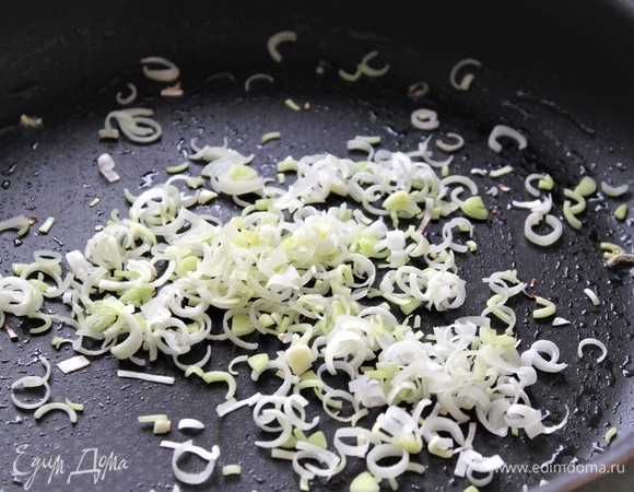 В ароматное оливковое масло выложить лук-порей. Обжарить, помешивая, 30 секунд.