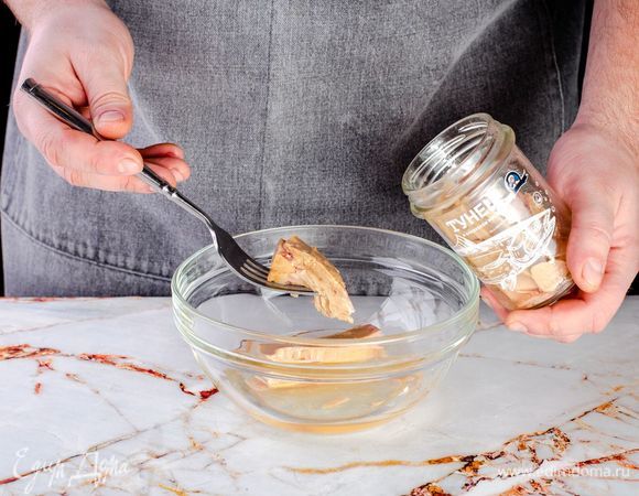 Тунца в оливковом масле ТМ «Капитан Вкусов» разомните вилкой. Масло слейте в сковороду, на которой будет готовиться рататуй.