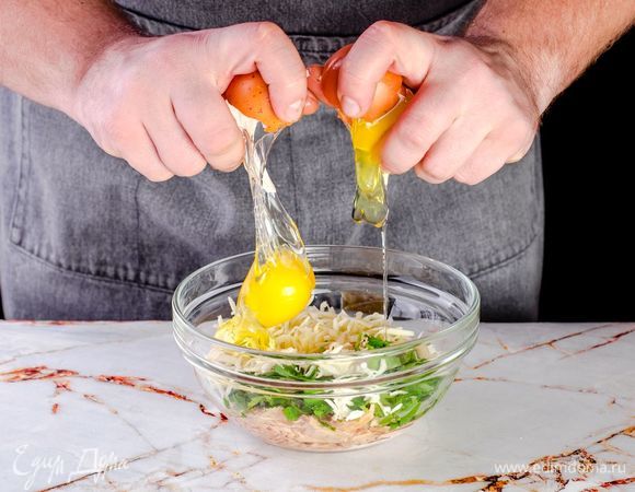 В чашку с тунцом добавьте рубленую кинзу, тертый сыр и яйца, все тщательно перемешайте.