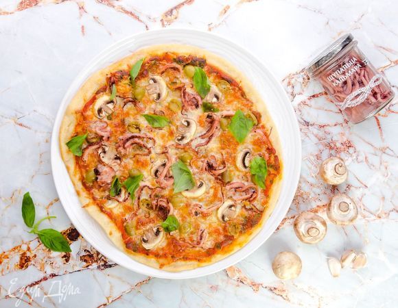 Посыпьте пиццу тертым сыром и выпекайте в заранее разогретой до 210°C духовке в течение 15–20 минут. Приятного аппетита!