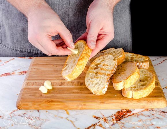 Натрите каждый кусочек чиабатты чесноком.
