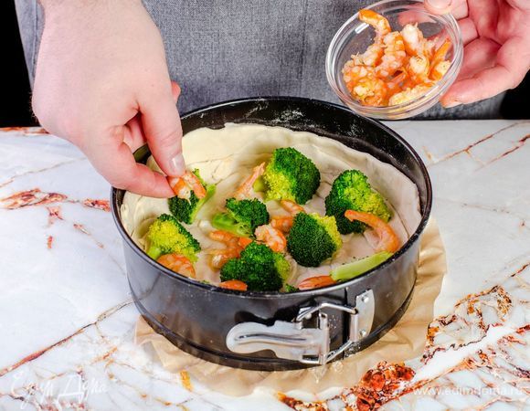 На тесто выложите брокколи и креветки.