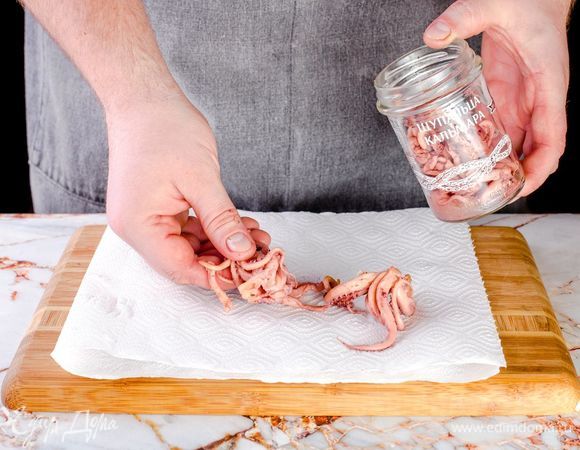 Слейте воду из банки, обсушите щупальца кальмаров ТМ «Капитан Вкусов» с помощью салфетки.