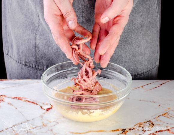 Поперчите щупальца, обваляйте в смеси яйца с сухарями.