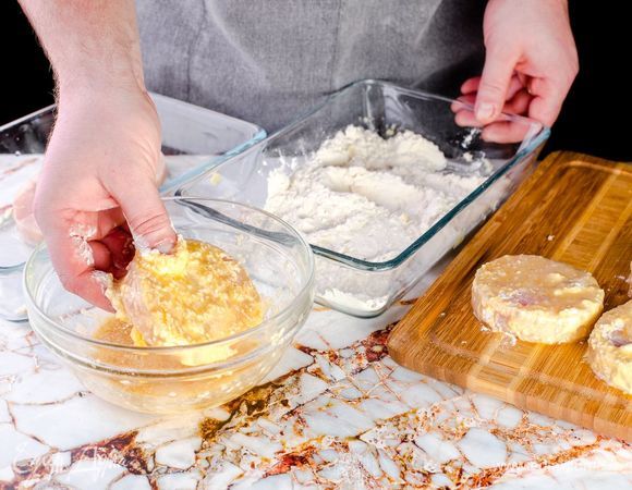 Обваляйте медальоны сначала в муке, затем — во взбитом яйце с кунжутом.