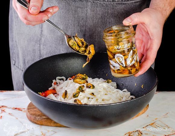 Откройте подкопченные мидии ТМ «Капитан Вкусов», слейте лишнюю жидкость, добавьте к остальным ингредиентам в сковороду.