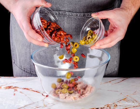 В салатник к тунцу отправьте нарезанные оливки и фасоль.