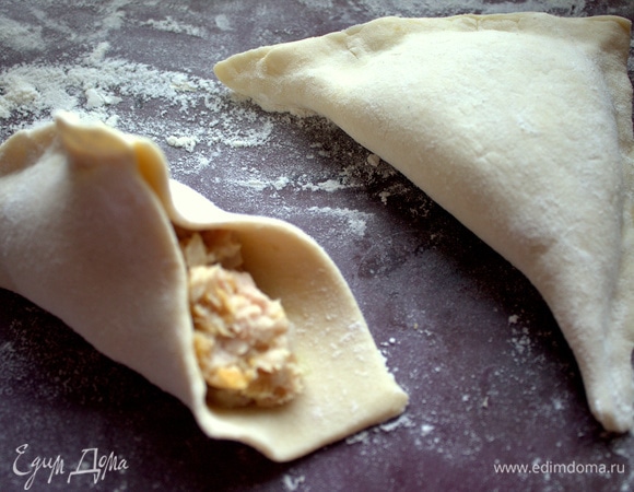 Складываем из теста треугольники и защипываем края.