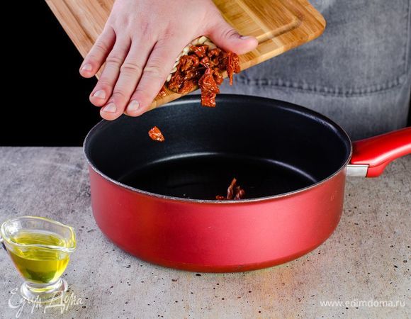 В глубокой сковороде разогрейте немного оливкового масла, поджарьте измельченный чеснок. Добавьте нарезанные вяленые помидоры. Посолите и поперчите.<br />
 