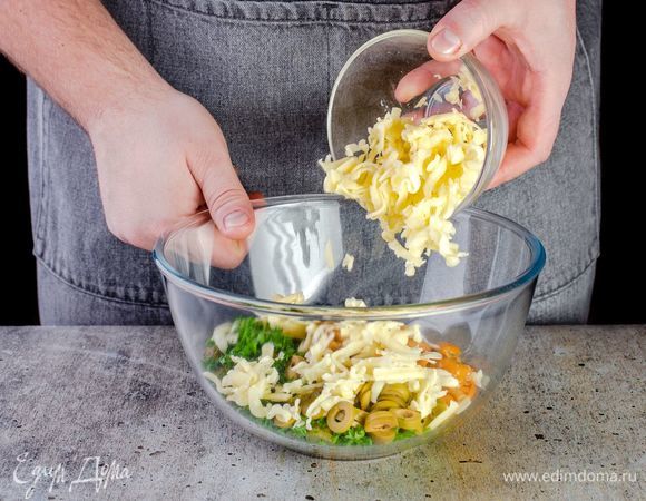 Добавьте в миску нарезанные ингредиенты, маринованные грибы и тертый сыр.