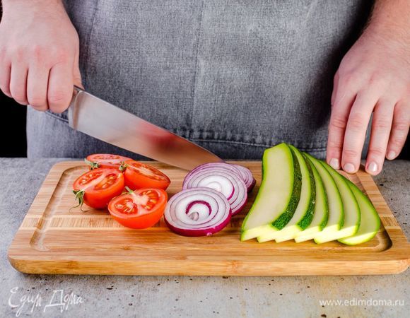 Овощи промойте и обсушите бумажными полотенцами. Цукини нарежьте слайсами, красный лук — кружочками, помидоры — пополам.