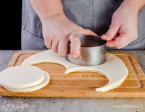 С помощью фигурной формочки вырежьте кружочки из тортилий. Выложите их в форму для капкейков в виде корзинок.