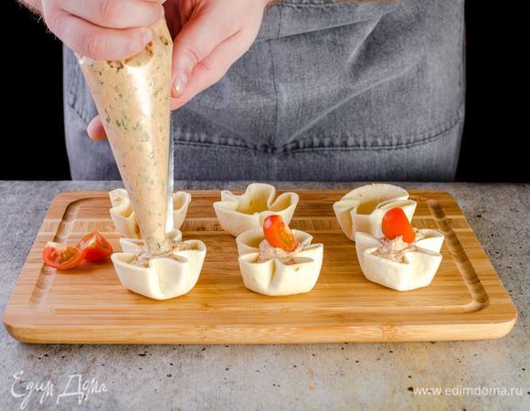 В подготовленные корзиночки выложите мусс из кондитерского мешка, украсьте помидорами черри. 