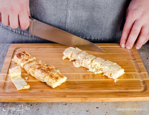 Сверните омлет в рулетик и нарежьте поперек.