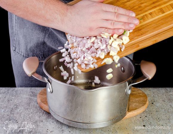 В кастрюле с толстым дном растопите сливочное масло, обжарьте лук и чеснок до мягкости.