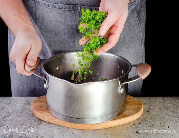 Влейте вино, снова перемешайте. Добавьте петрушку, накройте кастрюлю крышкой и готовьте, пока жидкость не закипит.