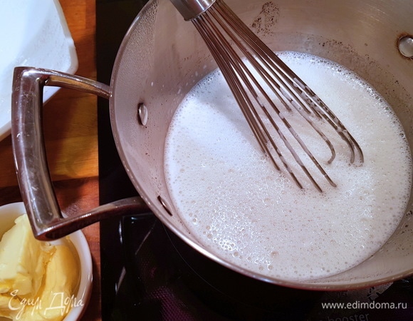 Затем переливаем получившуюся молочно-желтковую смесь обратно в кастрюлю, включаем средний огонь и завариваем крем до загустения, постоянно помешивая венчиком.