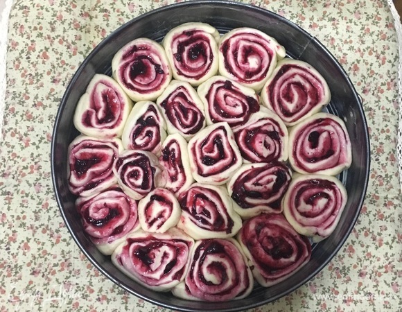 Уложить нарезанные булочки срезом вверх. Форму диаметром 24 см предварительно смазать сливочным маслом. Накрыть полотенцем и оставить на 20 минут в теплом месте на расстойку.