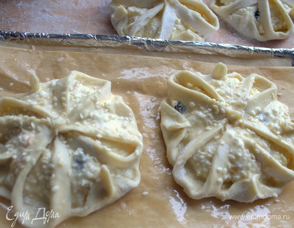 Перенести на смазанный пергамент в форме. Смазать взбитым яйцом и посыпать кунжутом.