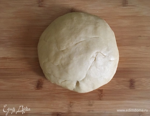 Влить жидкую массу к сухой и начать замешивать тесто. Вымешивать примерно 5 минут, затем переложить в чистую, смазанную маслом миску, накрыть полотенцем и оставить подойти на 1–1,5 часа в теплом месте.