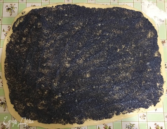 Тесто раскатать на припыленном мукой столе в прямоугольный пласт, смазать растопленным сливочным маслом, выложить сверху маковую начинку.