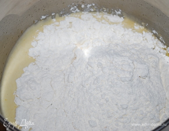 Сразу добавьте половину муки и перемешайте.