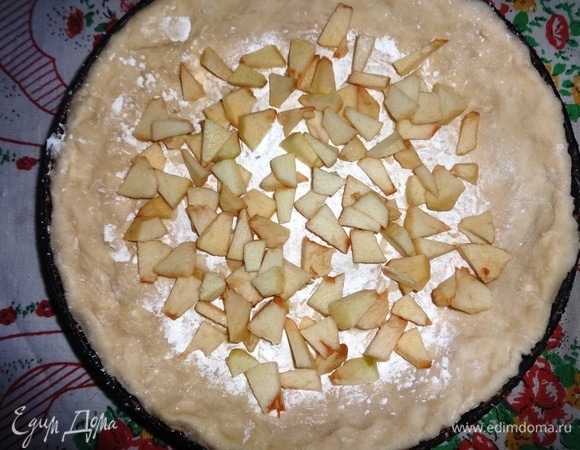 Посыпать дно заготовки из теста крахмалом, выложить яблоки.