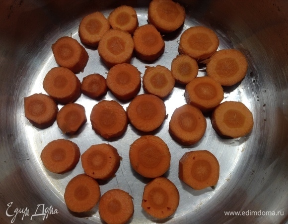 На дно широкой и невысокой кастрюли укладываем морковь, нарезанную кружками толщиной 1,5–2 см.