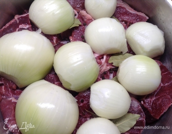 Луковицы большие режем на половинки, малые целиком оставляем, укладываем на мясо и плотно прижимаем.