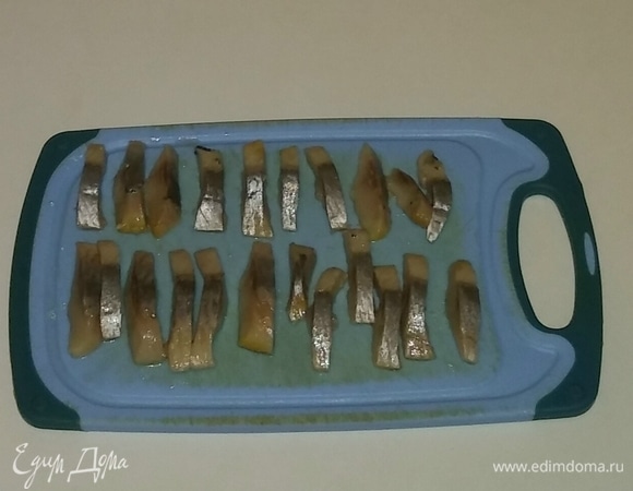 Затем режем кусочки селедки полосками толщиной 5 мм.