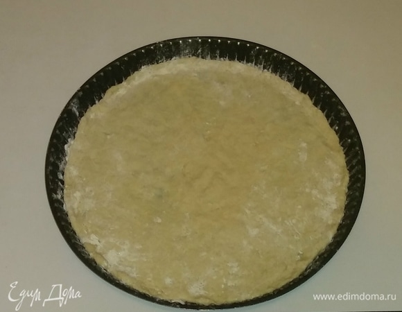 Берем форму для пиццы. Смазываем ее оливковым маслом и посыпаем чуть-чуть мукой, а затем выкладываем в форму тесто (его тоже чуть-чуть посыпаем мукой) и раскатываем.