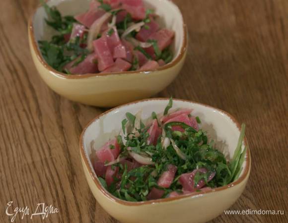 В небольшие пиалы разложить салатный микс, сверху шумовкой выложить тунца с зеленью.