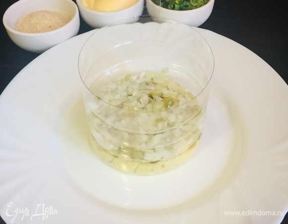 Берем форму для салата и начинаем укладывать его слоями. 1 слой — картофель. 2 слой — огурцы. 3 слой — лук.