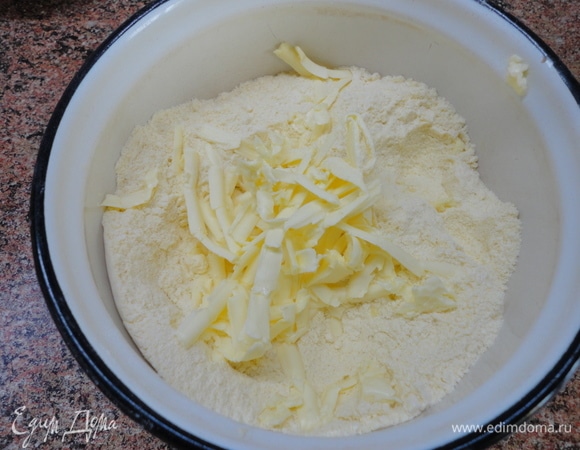 Пока остывает крем, готовим тесто. Смешиваем два вида муки с сахаром и разрыхлителем и натираем холодное сливочное масло.