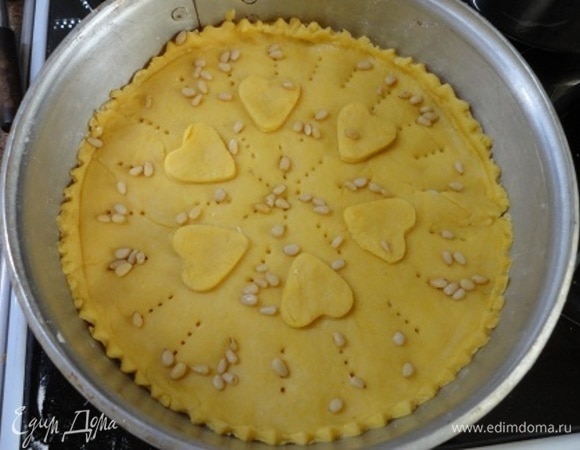 Вторую часть теста раскатываем и накрываем ею крем. Накалываем и посыпаем остатками орехов.