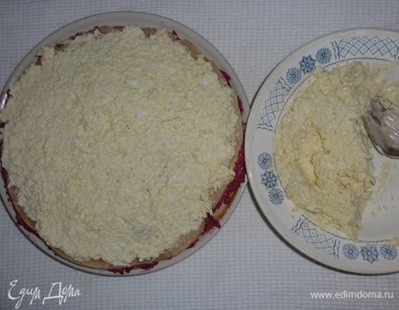 Положить блинчик и выложить на него половину яичной начинки, разровнять.