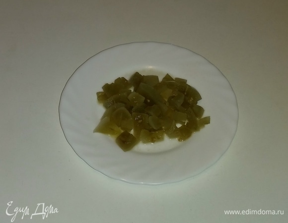 Затем режем кубиками соленый зеленый помидор.