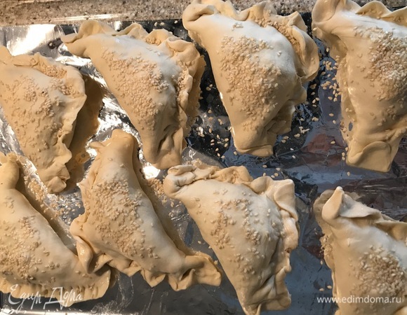 В тесто положить фарш. Слепить треугольник. Защипнуть края (или примять вилкой). Сделать пару проколов сверху деревянной палочкой или вилкой (аккуратно). Посыпать кунжутом. Выпекать 30–35 минут. Посматривайте — готовность зависит от возможностей вашей духовки.