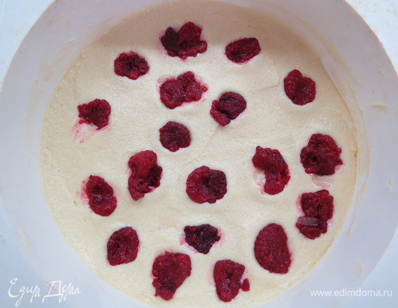 Полученное тесто выложить в форму (у меня силиконовая диаметром 18 см), сверху равномерно распределить ягоды малины. Выпекать 10 минут в разогретой до 200°C духовке.