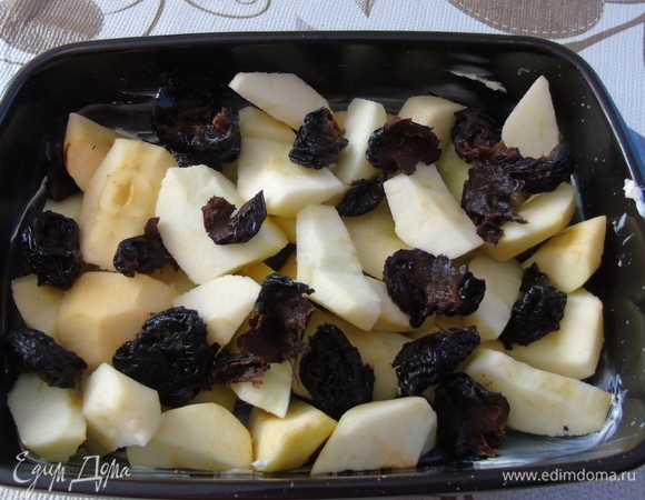 Форму смазать маслом. Яблоки очистить и нарезать кусочками. Сложить в форму вперемешку с кусочками чернослива.