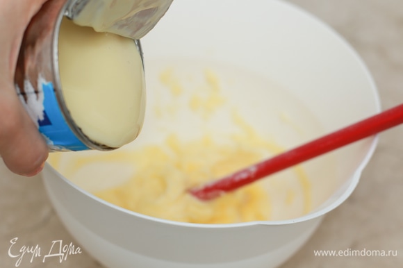 Пока выпекается корж, приготовьте крем. Крем для этих пирожных обычно делают самый простой — на сгущенке с маслом. Для этого заранее достаньте масло из холодильника, чтобы оно стало очень мягким, затем слегка взбейте его. Постепенно вливайте сгущенное молоко к маслу, каждый раз тщательно взбивая смесь миксером.