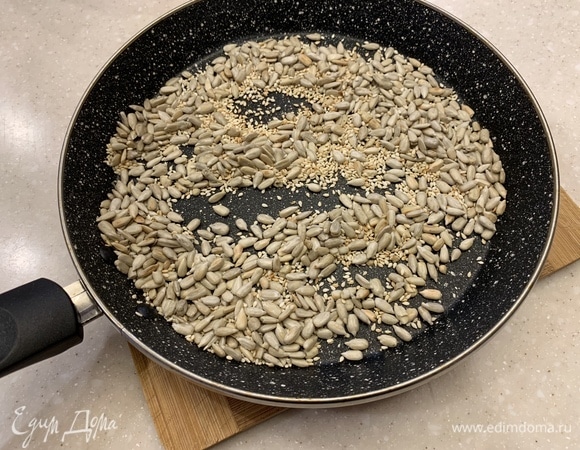 Семена подсолнуха и кунжута слегка подсушить в духовке или на сковороде. Изюм замочить в воде на несколько минут, затем отжать.