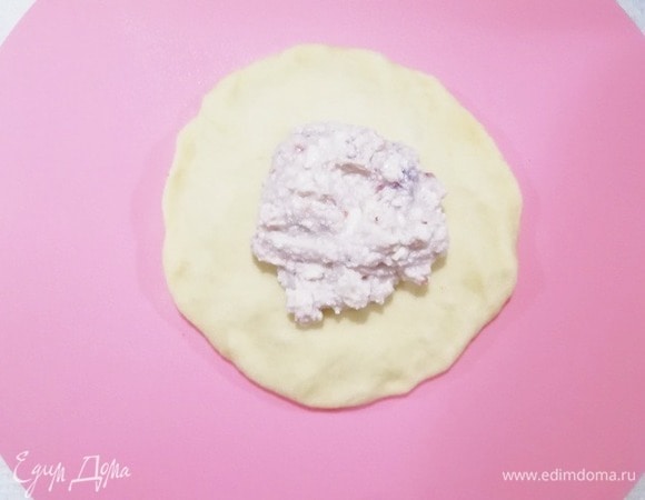 Шарики по 150 и 75 г руками расплющиваем, делая края немного тоньше середины. Кладем в центр начинку.