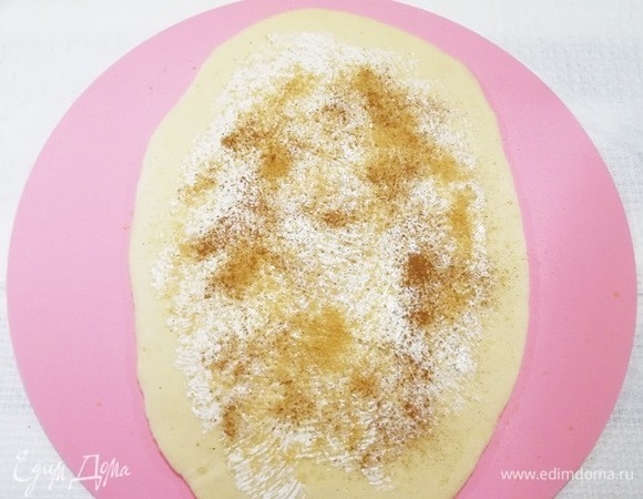 Большой шарик раскатываем в овальную лепешку, немного смазываем растопленным сливочным маслом, посыпаем сахаром и корицей.